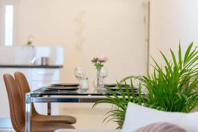 a dining room with a table with chairs and plants at Koukaki lux 2BD 1master ap next to Acropolis in Athens