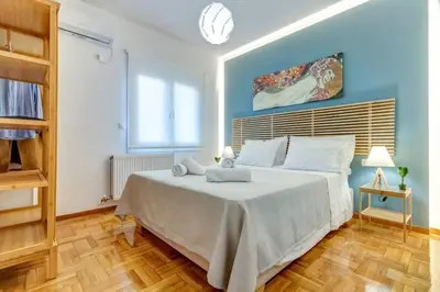 a bedroom with a large bed with blue walls and wooden floors at Koukaki lux 2BD 1master ap next to Acropolis in Athens