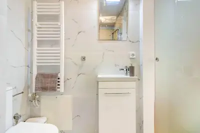 a white bathroom with a toilet and a sink at Koukaki lux 2BD 1master ap next to Acropolis in Athens