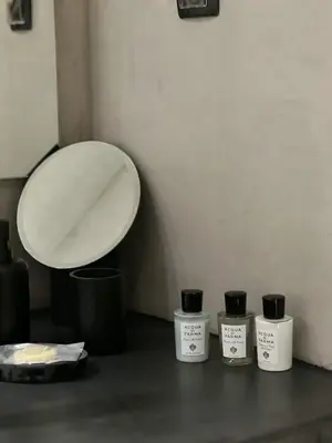 three bottles ofodorizers sitting next to a mirror at CASAGOLD Glyfada Luxury Apartment Near The Sea in Athens