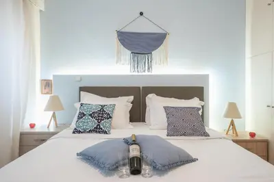 a bedroom with a white bed with blue pillows at Elegant Ariadne, 2 Bedroom Apartment, by Acropolin in Athens