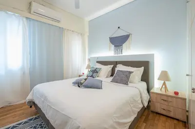 a bedroom with a large white bed with blue pillows at Elegant Ariadne, 2 Bedroom Apartment, by Acropolin in Athens