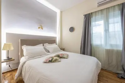 a bedroom with a white bed with two pillows on it at Elegant Ariadne, 2 Bedroom Apartment, by Acropolin in Athens