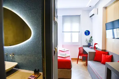 a bathroom with a couch and a sink in a room at CentraL44 LoL RooM-Ermou Street in Athens