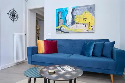 a blue couch with colorful pillows in a living room at Acropolis 2BD Private Entrance Apt in Athens