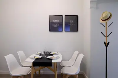 a dining room with a white table and white chairs at Acropolis 2BD Private Entrance Apt in Athens