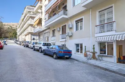 a blue car parked on the side of a building at Acropolis 2BD Private Entrance Apt in Athens