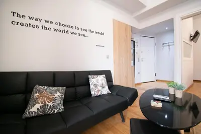 a living room with a black couch and a table at Hidden Gem Acropolis View in Athens