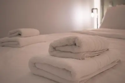 a pile of towels sitting on top of a bed at Hidden Gem Acropolis View in Athens