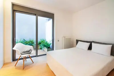 a bedroom with a white bed and a white chair at Elegant and Private Living by Neuvel in Athens