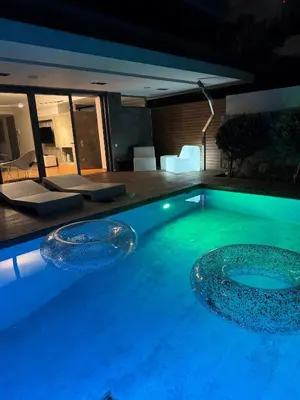 a swimming pool at night with two bowls in it at Elegant and Private Living by Neuvel in Athens