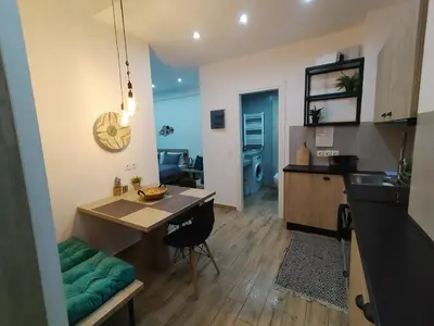 a kitchen and living room with a table and a dining room at Argous - Athens City Center Apartment in Athens
