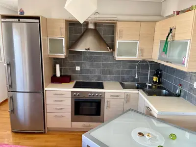 a kitchen with a stainless steel refrigerator and a sink at ΔΙΑΜΕΡΙΣΜΑ ΜΕ ΘΕΑ in Athens