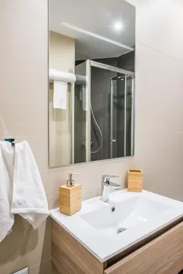a bathroom with a white sink and a mirror at A25 Pristine & Sunny flat with balcony at downtown Athens in Athens