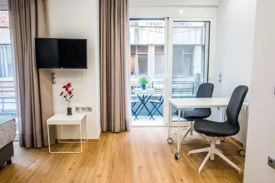 a hotel room with a desk and chairs and a window at A25 Pristine & Sunny flat with balcony at downtown Athens in Athens