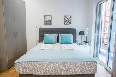 a bedroom with a large bed with blue pillows at A25 Pristine & Sunny flat with balcony at downtown Athens in Athens