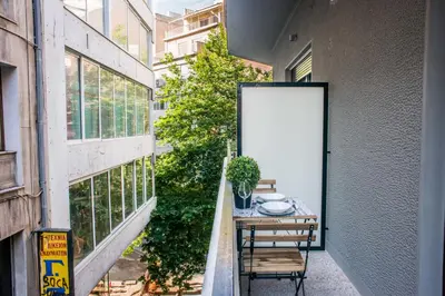 a small balcony with a table and a white door at A25 Pristine & Sunny flat with balcony at downtown Athens in Athens