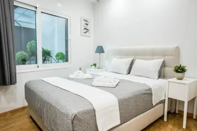 a white bedroom with a bed and a window at A26 Premium flat near Monastiraki square in Athens in Athens
