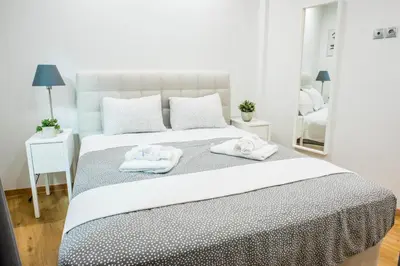 a white bedroom with two towels on a bed at A26 Premium flat near Monastiraki square in Athens in Athens