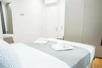 a bedroom with a bed with towels and a mirror at A26 Premium flat near Monastiraki square in Athens in Athens
