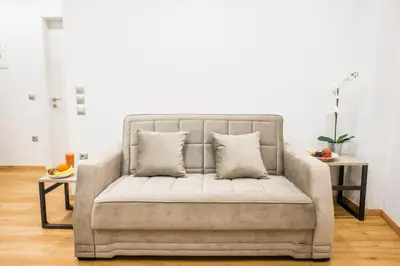 a couch in a living room with two pillows at A26 Premium flat near Monastiraki square in Athens in Athens