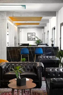 a lobby with black leather furniture and blue chairs at Play Theatrou Athens a member of Brown Hotels in Athens