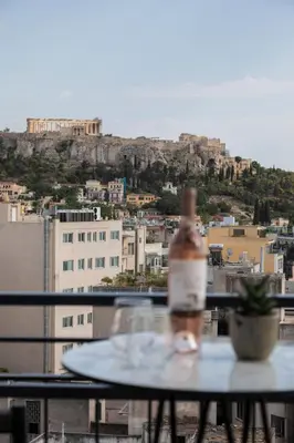 a bottle of wine sitting on top of a table at Play Theatrou Athens a member of Brown Hotels in Athens