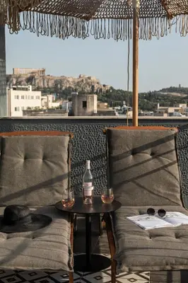 a table and a chair with a bottle on a table at Play Theatrou Athens a member of Brown Hotels in Athens