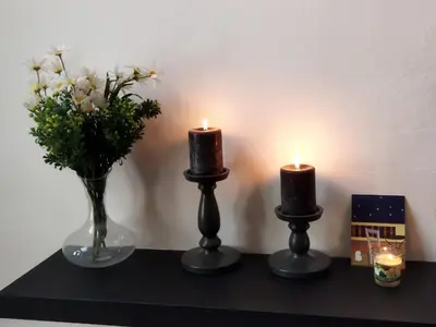 two candles and a vase with flowers on a shelf at Thisio Loft in Athens