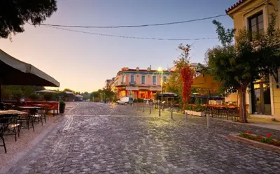 a cobblestone street with tables and chairs and buildings at Thisio Loft in Athens