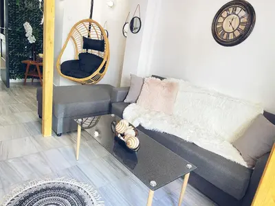 a living room with a couch and a clock on the wall at Thisio Loft in Athens