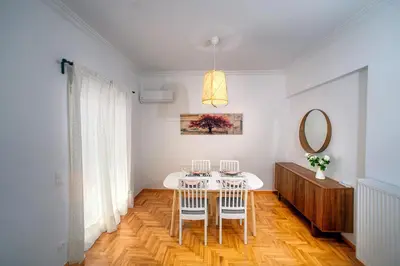 a dining room with a table and chairs and a mirror at Acropolis area family friendly 2bdr apartment in Athens