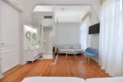 a bathroom with a couch and a sink and a mirror at 1900 ATHENIAN HOUSE in Athens