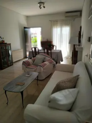 a living room with two couches and a table at Emily`s vacation house in Kalívia Thorikoú