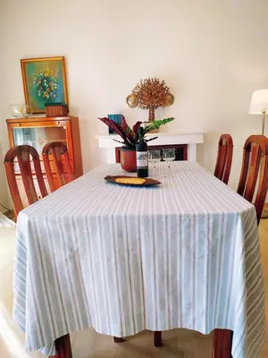 a dining room table with a blue and white striped table cloth at Emily`s vacation house in Kalívia Thorikoú