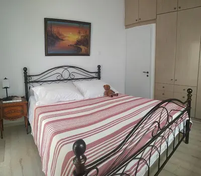 a teddy bear sitting on a bed in a bedroom at Emily`s vacation house in Kalívia Thorikoú