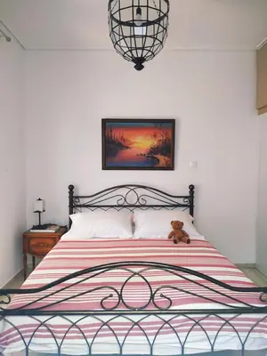 a bedroom with a bed with a teddy bear on it at Emily`s vacation house in Kalívia Thorikoú