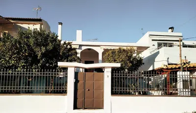 a white house with a gate and a fence at Emily`s vacation house in Kalívia Thorikoú