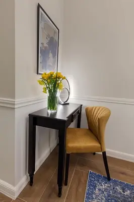 a desk with a vase of flowers and a chair at Classic Hotel by Athens Prime Hotels in Athens