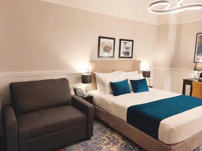 a bedroom with a bed and a chair at Classic Hotel by Athens Prime Hotels in Athens