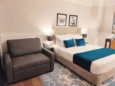 a bedroom with a bed and a chair at Classic Hotel by Athens Prime Hotels in Athens