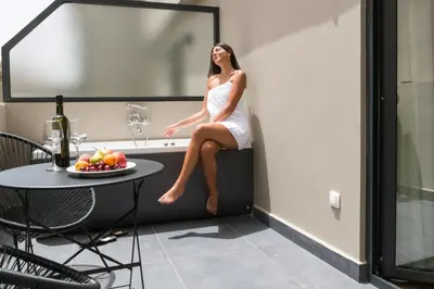 a woman sitting on a ledge in a room with a table at Classic Hotel by Athens Prime Hotels in Athens