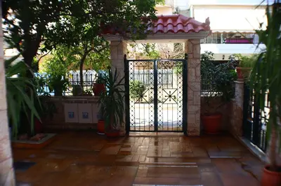 an open gate in a courtyard with potted plants at Filoxenia Apartment in Athens