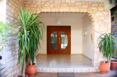 a hallway with two potted plants and a wooden door at Filoxenia Apartment in Athens