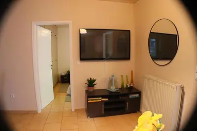 a living room with a television and a mirror at Filoxenia Apartment in Athens
