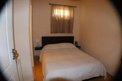 a bed in a small room with a window at Filoxenia Apartment in Athens