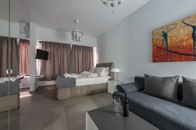 a living room with a couch and a bed at Iguana Gold Luxury Suites 1min from Ermou str in Athens