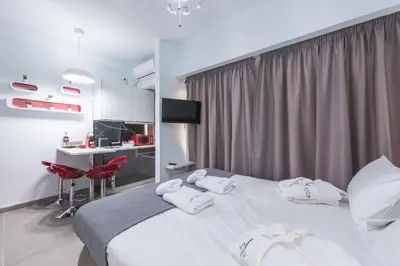 a bedroom with a large white bed with red chairs at Iguana Gold Luxury Suites 1min from Ermou str in Athens