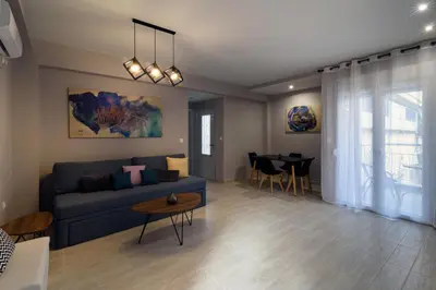 a living room with a blue couch and a table at Athens Chic House in Athens