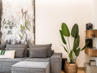 a living room with a gray couch and a plant at Tree Olive Athens in Athens